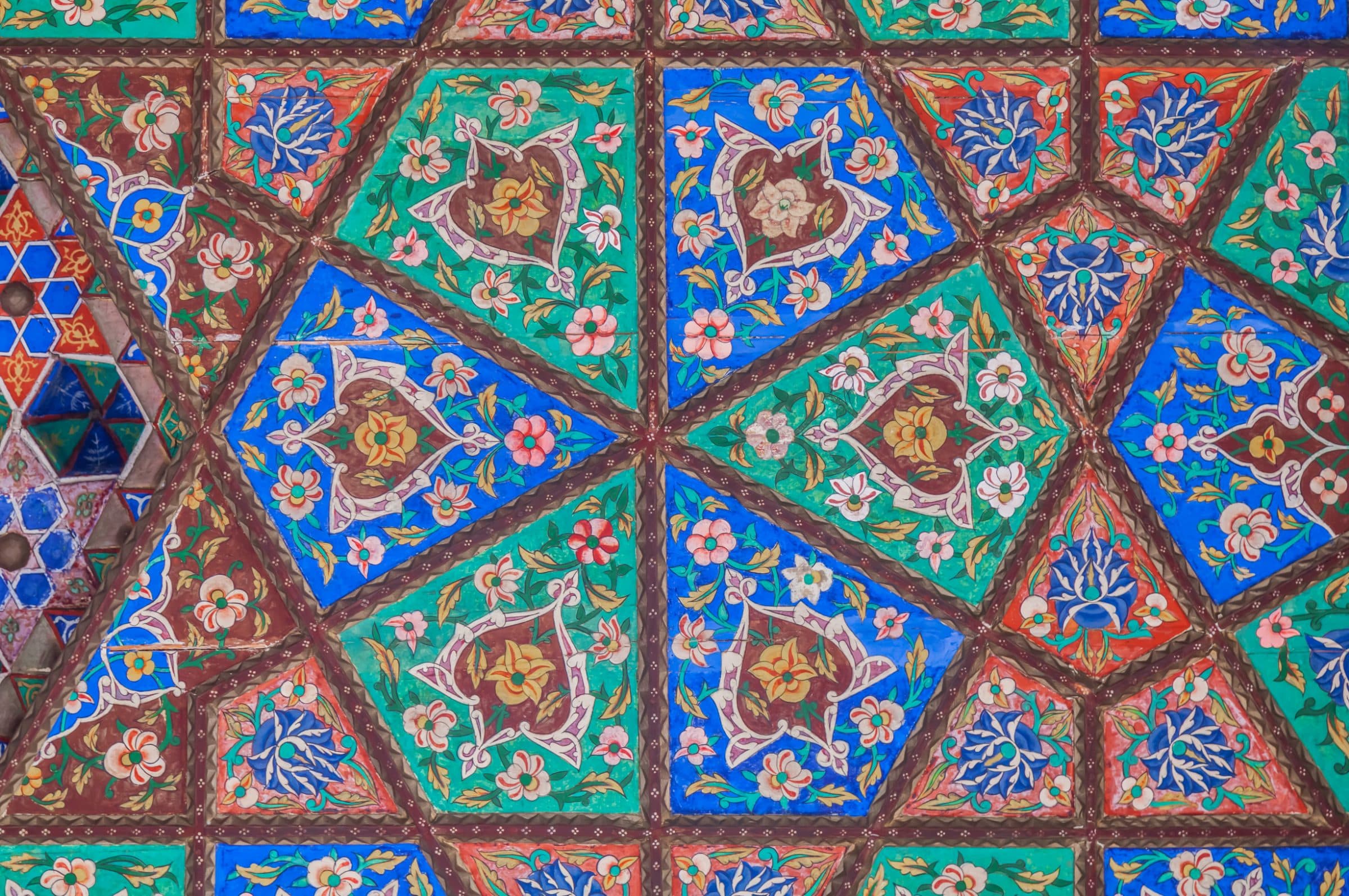 A painted geometric ceiling in blue, green and red.